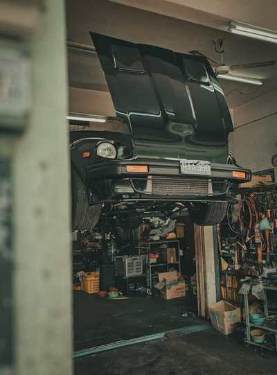 Classic car raised on a garage lift with electrical equipment nearby