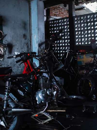 Motorcycle frame and engine in a dark garage workshop