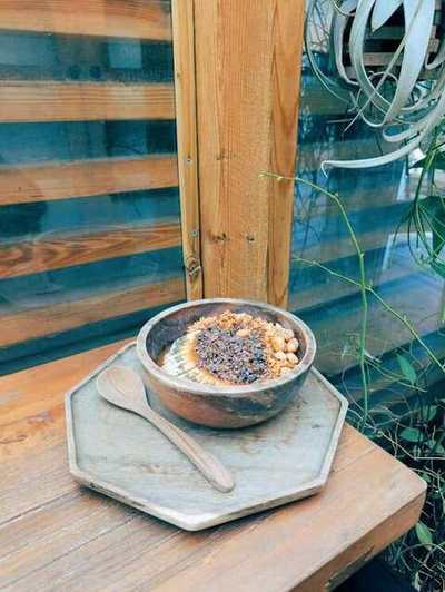 Wooden bowl of fruit and granola on a rustic table