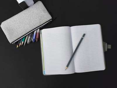 Open notebook with pen and pencil on a desk