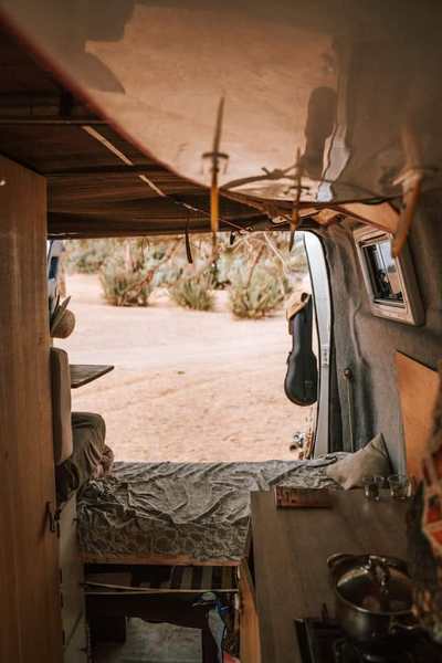 Camper van interior with bed, storage, and compact sink